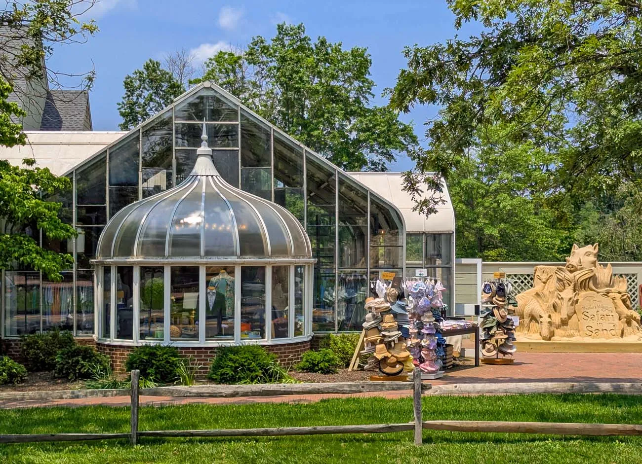 clickbizhub distinctive domed section and peaked roof at fox and holly surrounded by lush green lawns and mature trees with safari in sand sculpture visible in foreground featuring carved safari animals