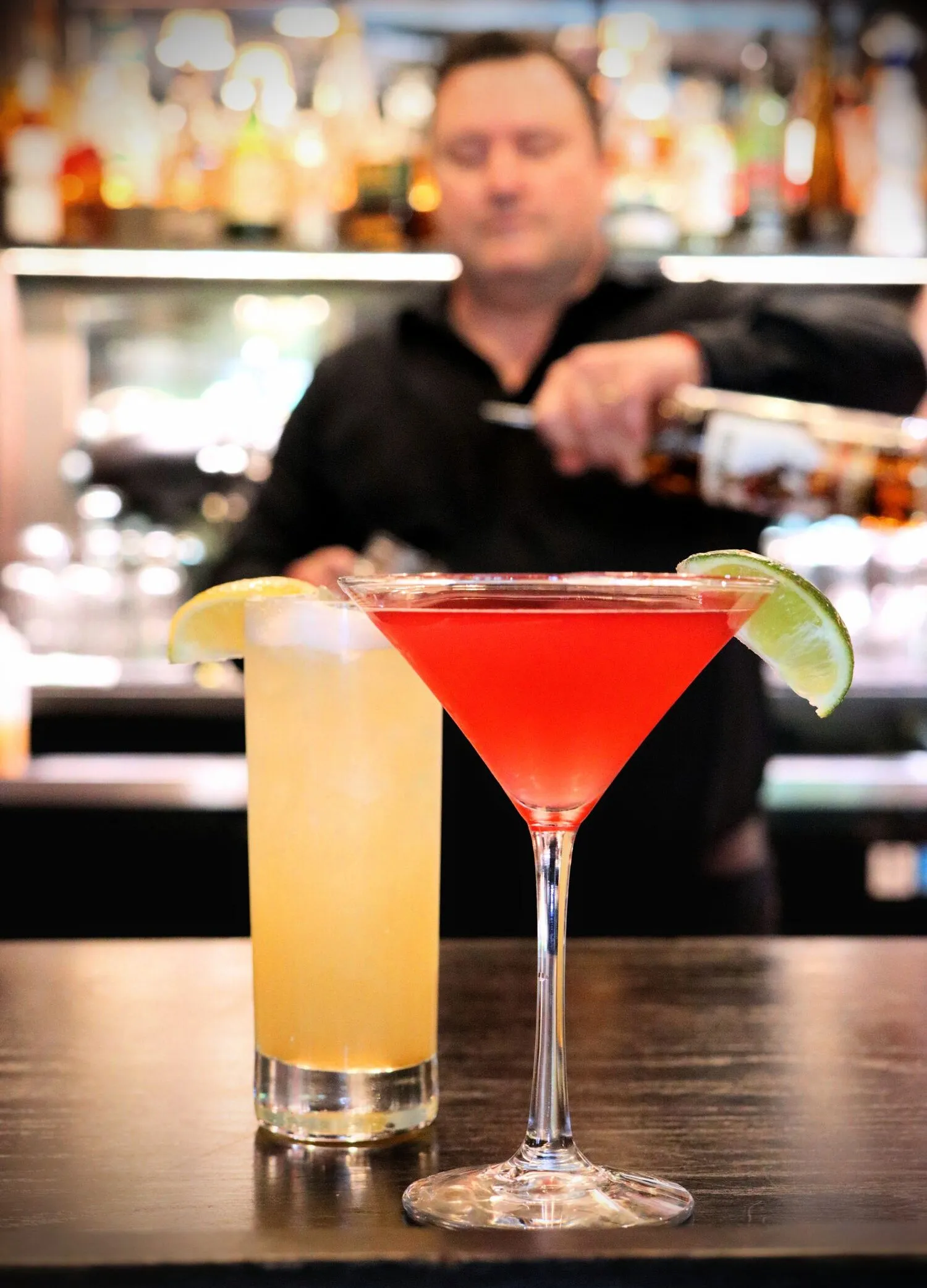 clickbizhub cocktails at red fox lounge a bartender is pouring in the background two colorful cocktails in the foreground