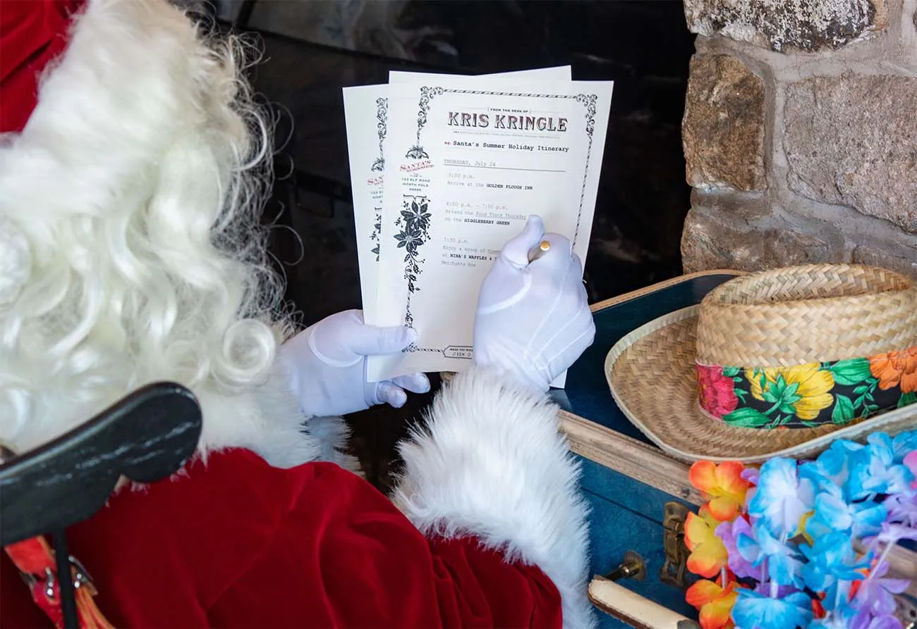 clickbizhub santa claus in traditional red suit and white gloves holding and reading